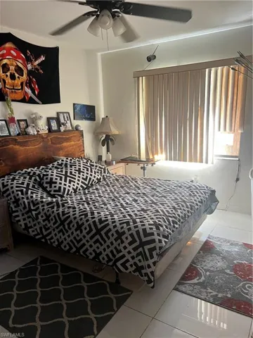 Bedroom with light tile patterned floors and a ceiling fan
