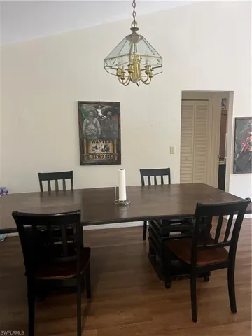 Dining room with wood finished floors and a chandelier