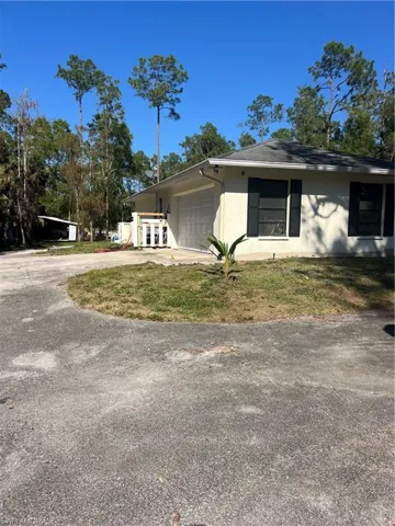 View of side of home featuring concrete driveway, a garage, and stucco siding