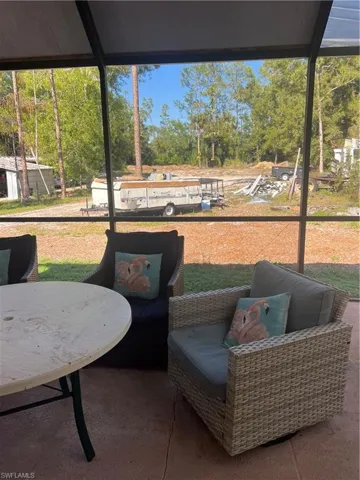 Sunroom / solarium featuring view of wooded area