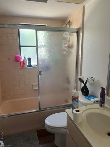 Full bathroom with bath / shower combo with glass door and vanity