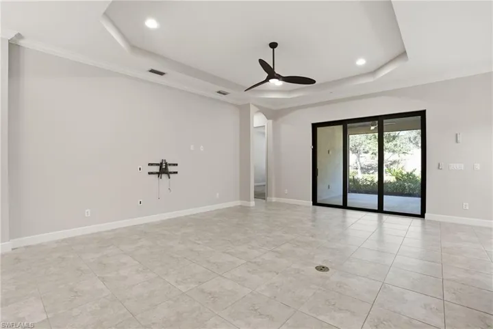 Empty room with crown molding, arched walkways, ceiling fan, recessed lighting, and light tile patterned floors