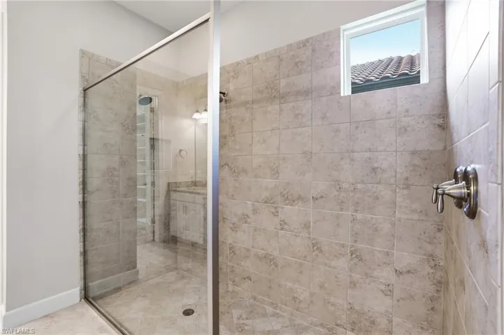 Bathroom featuring a shower stall and baseboards