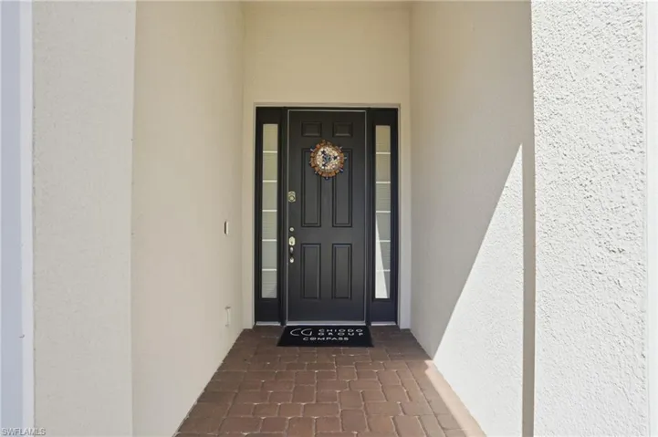 View of exterior entry featuring stucco siding and covered porch
