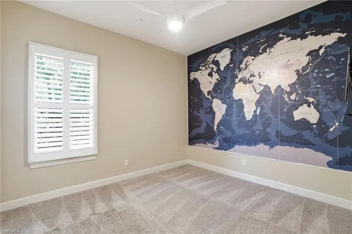 Carpeted empty room with baseboards and ceiling fan