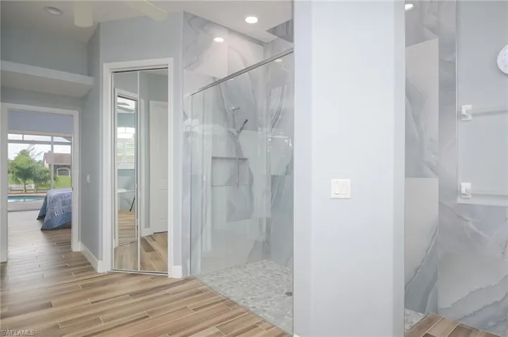 Bathroom with a tile shower and hardwood / wood-style flooring