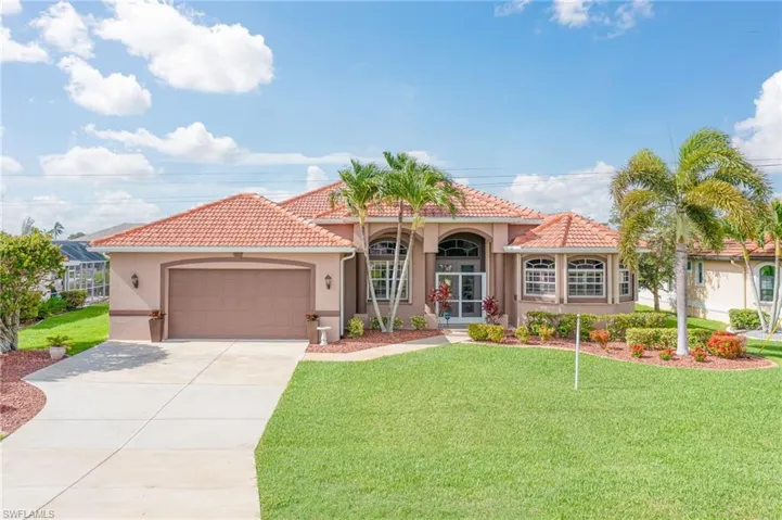 Mediterranean / spanish home featuring a front yard and a garage