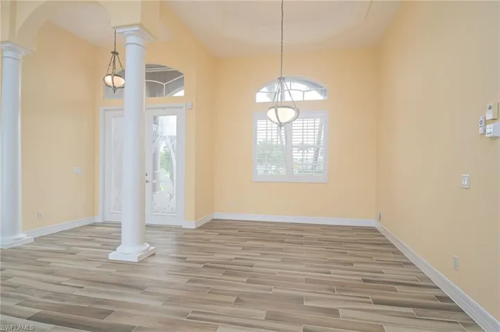 Spare room with hardwood / wood-style flooring and decorative columns