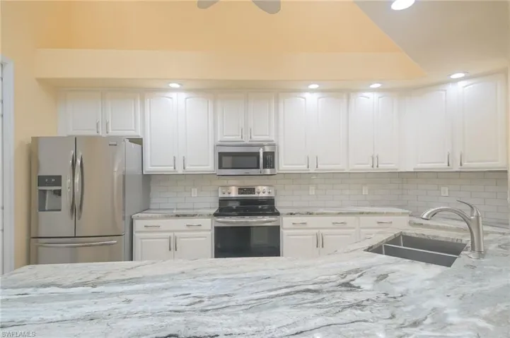 Kitchen with sink, white cabinets, and stainless steel appliances