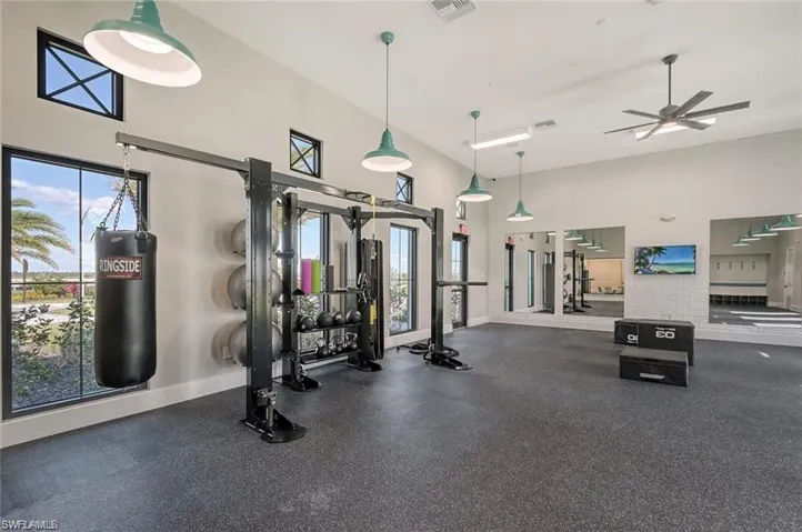 Exercise room featuring a high ceiling and a ceiling fan