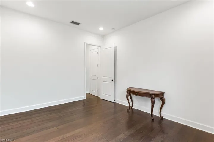 Spare room featuring dark wood-style floors and recessed lighting