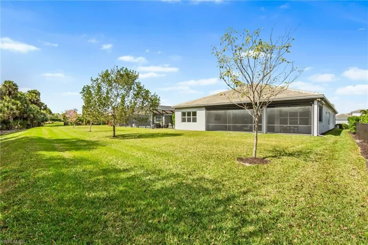 Rear view of house with a sunroom and a yard