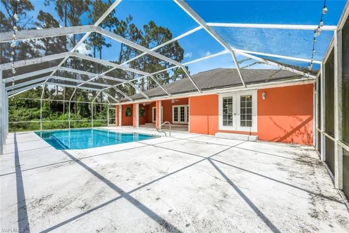 Outdoor pool featuring french doors, a patio, ceiling fan, and a lanai