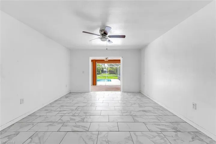 Spare room with light marble finish flooring and ceiling fan