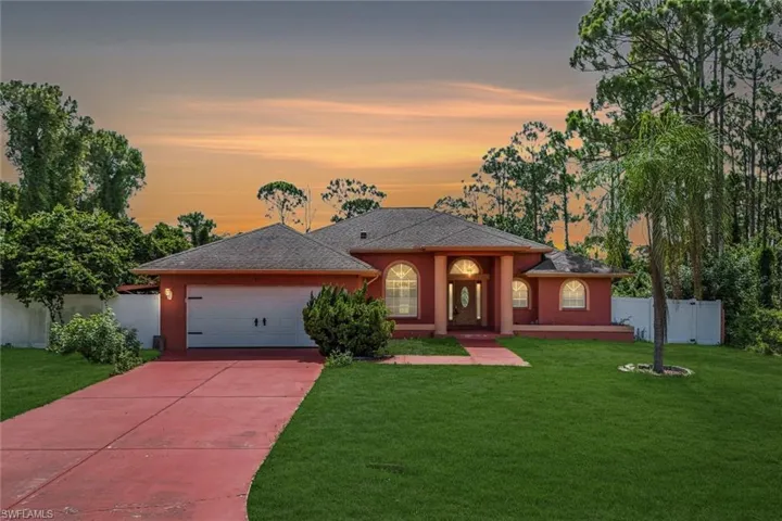 View of front of property with driveway, a garage, stucco siding, and roof with shingles