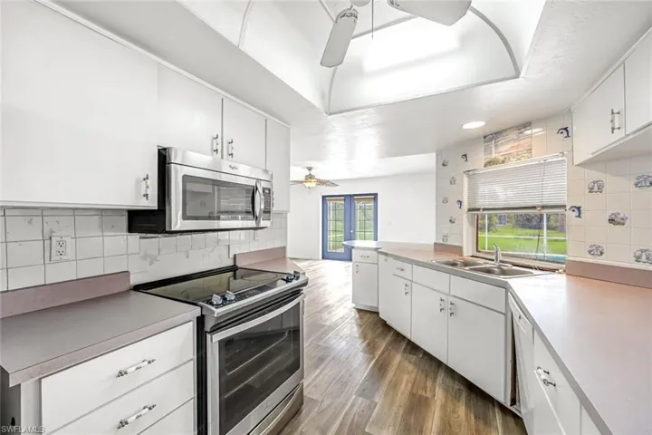 Kitchen with stainless steel appliances, ceiling fan, decorative backsplash, light countertops, and recessed lighting