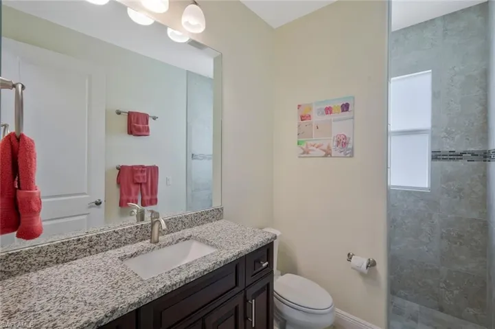 Bathroom with vanity and tiled shower