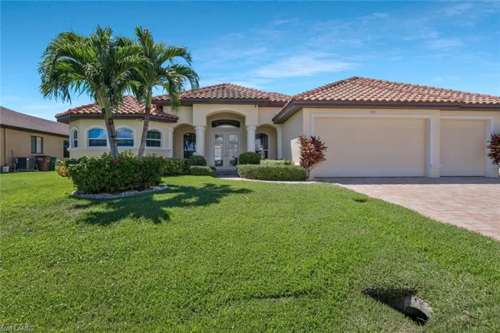 Mediterranean / spanish-style house featuring stucco siding, french doors, decorative driveway, a front lawn, and a tile roof