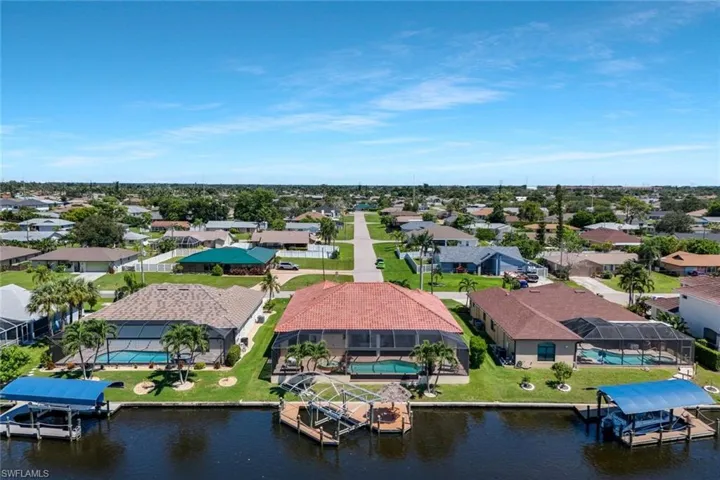 Aerial perspective of suburban area featuring a nearby body of water