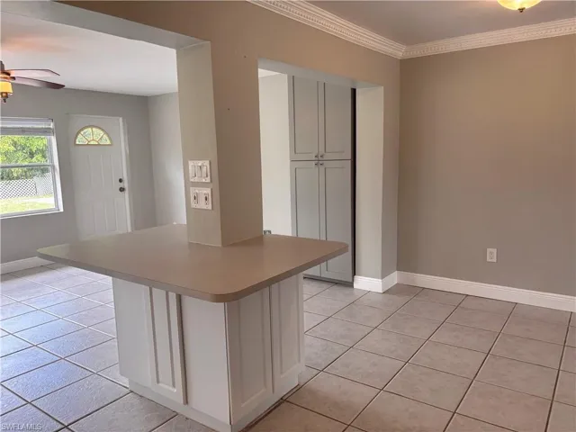 Featuring  tiled flooring, extra storage cabinet and crown molding