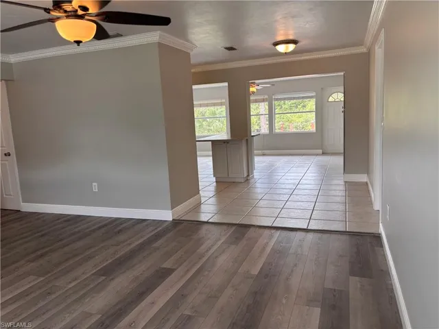 Interior space featuring wood plank flooring, neutral wall paint, and crown molding