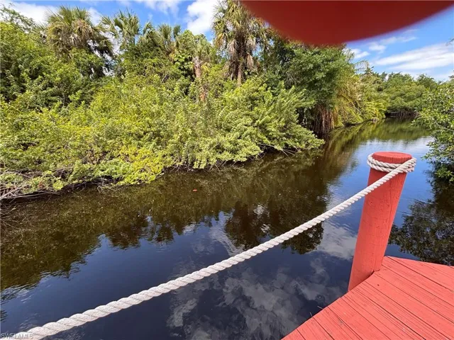 Waterfront access with a red-painted dock and a rope railing