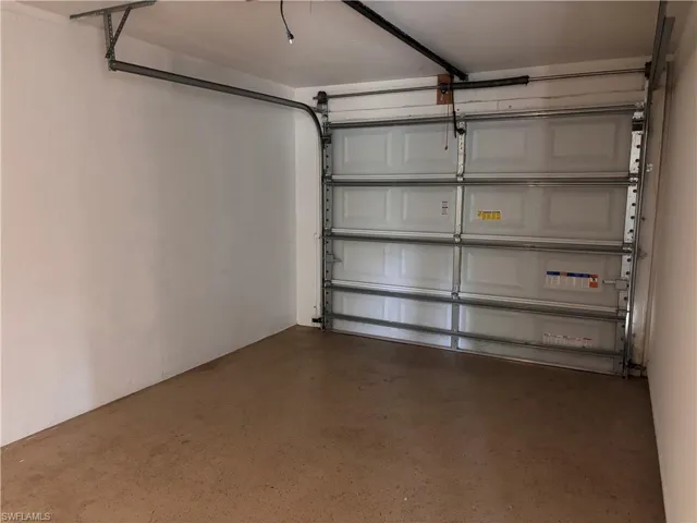 Garage with a roll-up door and a finished concrete floor