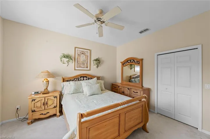 Bedroom featuring a closet, light colored carpet, and ceiling fan