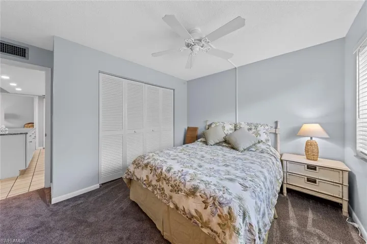 Carpeted bedroom, ceiling fan, and a closet