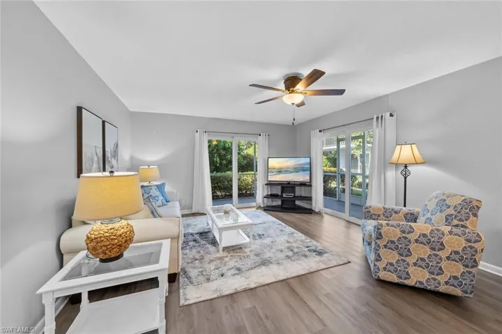 Living room with hardwood / wood-style floors, ceiling fan, and plenty of natural light