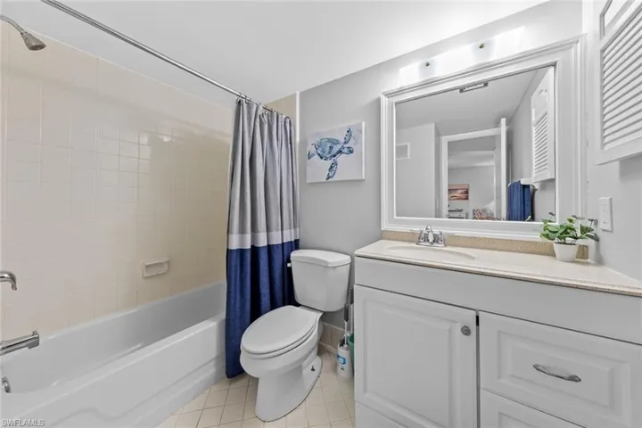 Full bathroom featuring tile patterned floors, vanity, shower / bath combination with curtain, and toilet