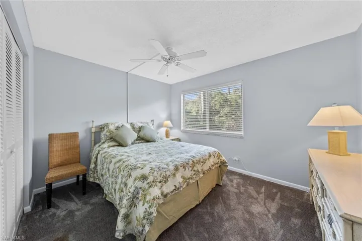 Carpeted bedroom with ceiling fan, and a closet