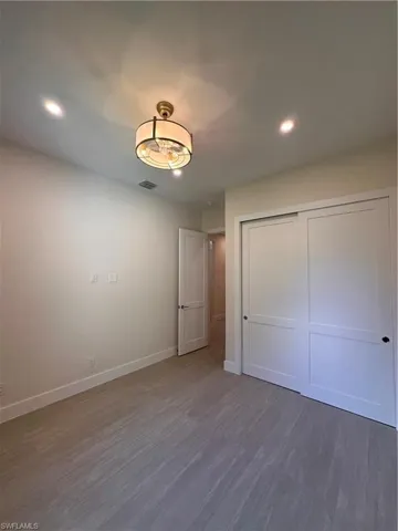 Unfurnished bedroom with wood finished floors, recessed lighting, and a closet