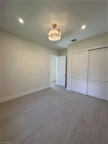 Unfurnished bedroom with recessed lighting, a closet, and wood finished floors
