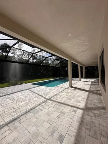 Outdoor pool with a patio area, a sunroom, and a lanai