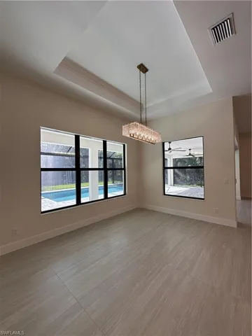 Spare room featuring a tray ceiling and crown molding