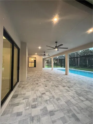 Outdoor pool featuring a patio area and glass enclosure