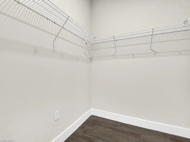 Full bathroom featuring two vanities, a stall shower, wood tiled floors, and recessed lighting