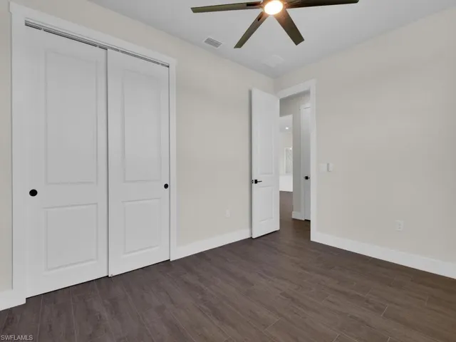 Unfurnished bedroom featuring wood tiled floors, a ceiling fan, and a closet