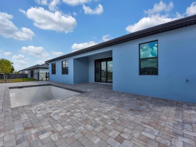 Back of house with stucco siding and a patio