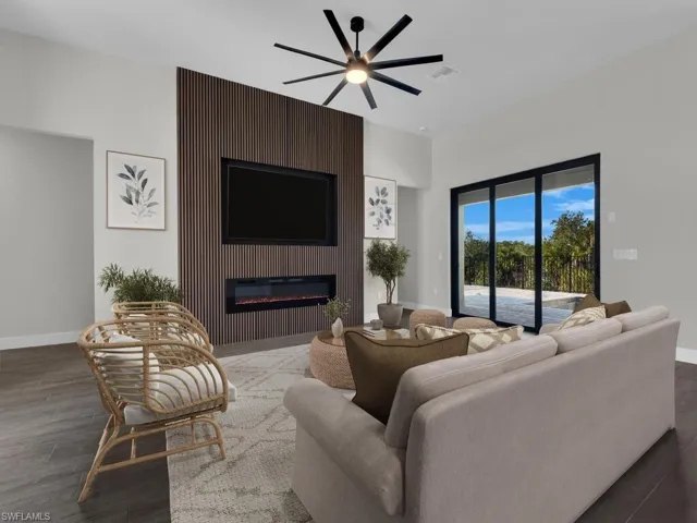 Living room with ceiling fan, wood finish floors, and a large fireplace
