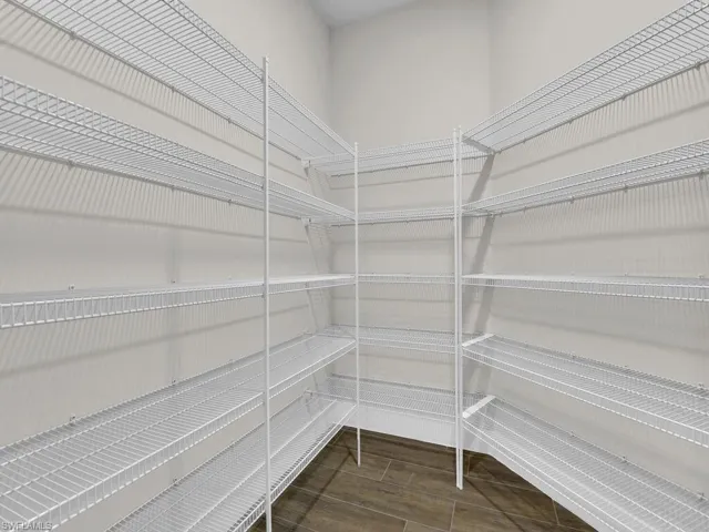 Spare room featuring lofted ceiling, wood finish floors, and suspended lighting