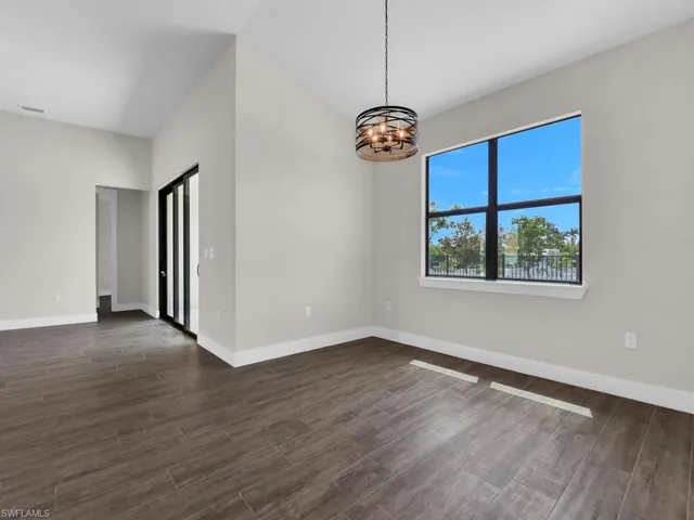 Kitchen featuring open floor plan, a ceiling fan, wood finish floors, light stone counters, and dual tone cabinets