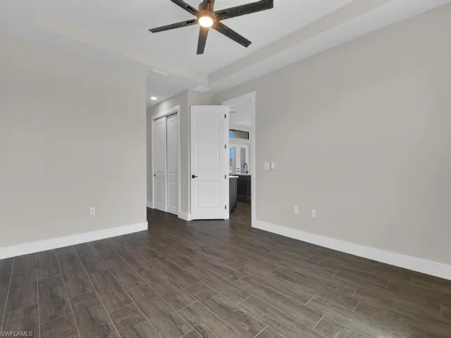 Empty room with wood finish floors and a ceiling fan