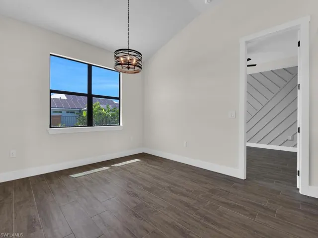 Unfurnished living room with a ceiling fan, a fireplace, wood finish floors, french doors, and a high ceiling