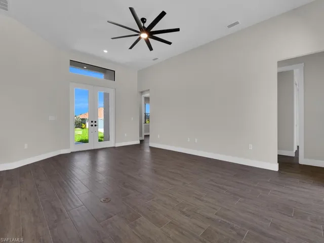 Kitchen featuring white cabinetry, stainless steel appliances, a center island with sink, a breakfast bar area, and backsplash