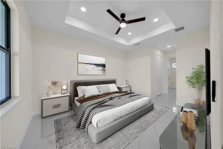 Bedroom with a tray ceiling, recessed lighting, light marble finish floors, and a ceiling fan