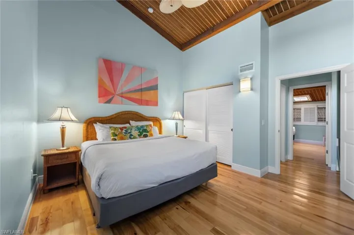 Bedroom with a vaulted wooden ceiling, light wood finished floors, a closet, and ceiling fan