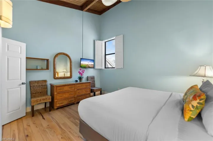 Bedroom featuring light wood-type flooring and a wooden ceiling with exposed beams