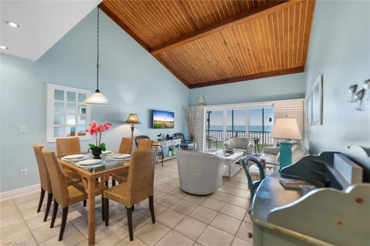 Dining room featuring light tile patterned floors and a vaulted wooden ceiling
